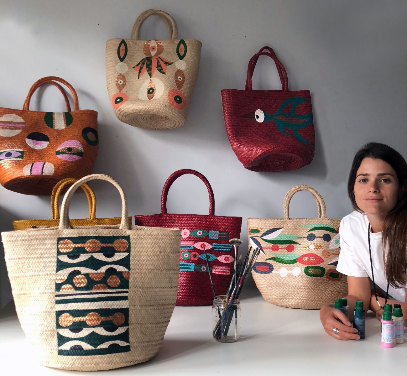 A artista plástica Naia Ceschin com as bolsas de trançados tupinambás com pintura exclusiva para a ação Artiz +